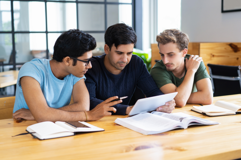 Students preparing for Indian government exams after graduation with books and laptops