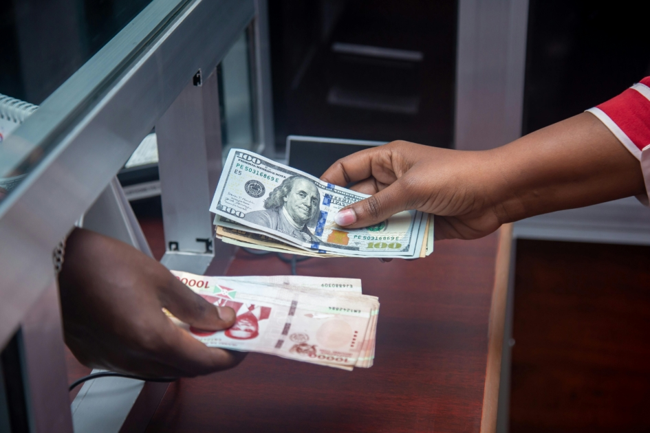 Bank teller assisting a customer with a transaction inside a modern PNC Bank branch