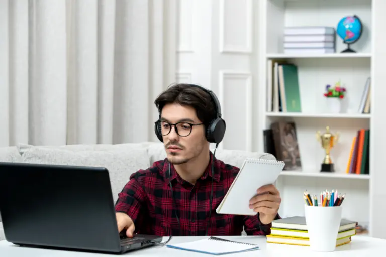 Student preparing for SSC CGL exam with books and laptop